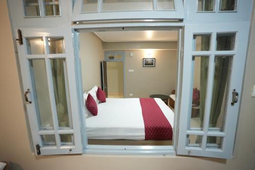 a bedroom with an open door with a bed at TheMapleVillageFarmstay in Gangtok