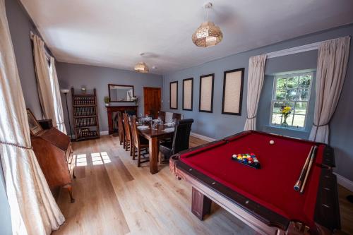 a room with a pool table and a dining room at Large country house with garden, outdoor spa area & games room with Hot Tub and Fire Pit in Wigtown