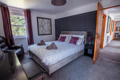 ein Schlafzimmer mit einem Bett, auf dem zwei braune Schuhe stehen in der Unterkunft Large country house with garden, outdoor spa area & games room with Hot Tub and Fire Pit in Wigtown