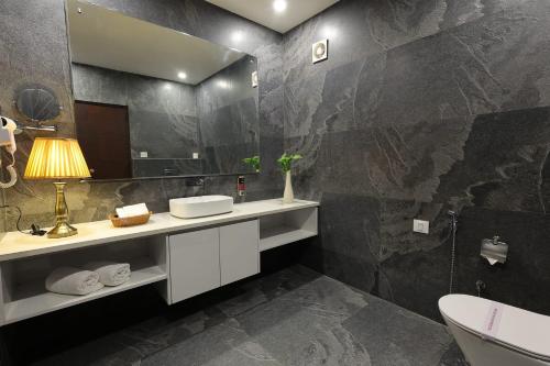 un bagno con lavandino e specchio di Corbett Tusker Trail a Kāshīpur