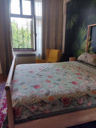 a bedroom with a bed with a floral bedspread and a window at Apartments My Zagreb in Zagreb