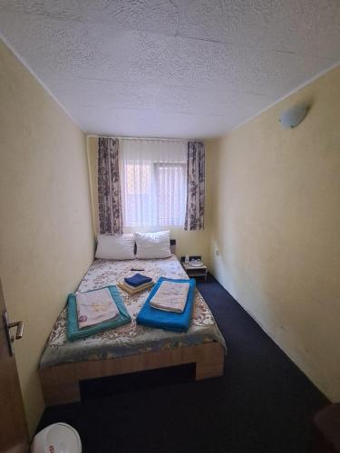 a small bedroom with a bed with a window at Casa Vlad in Costinesti