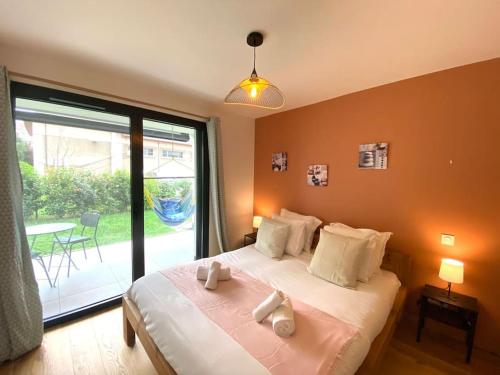 une chambre avec un lit et une grande fenêtre dans l'établissement Astoria - parking, vélos, jardin et terrasse, à Annecy