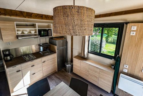 une cuisine dans un camping-car avec une table et un lustre dans l'établissement Camping Onlycamp Tours Val de Loire, à Saint-Avertin