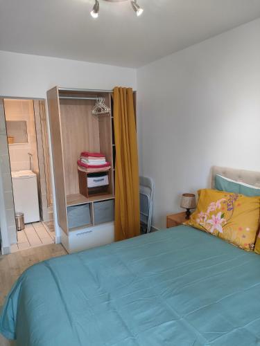 - une chambre avec un lit bleu et un placard dans l'établissement Location d'appartements 47 m, à Paris