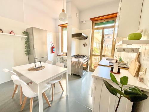 a kitchen with a white table and white chairs at Flaminio Luxury Home - City Center in Rome