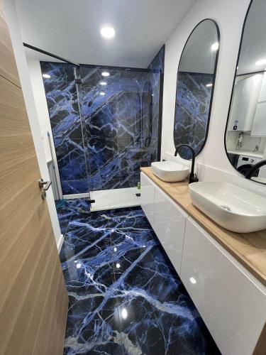 une salle de bain avec un sol en marbre bleu et un lavabo dans l'établissement L'azur Elite - T4 proche mer - Terrasse - Parking, à Sète
