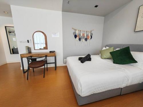 a bedroom with a bed and a table and a desk at Harmonee Homes at The Hub SS2, PJ in Petaling Jaya