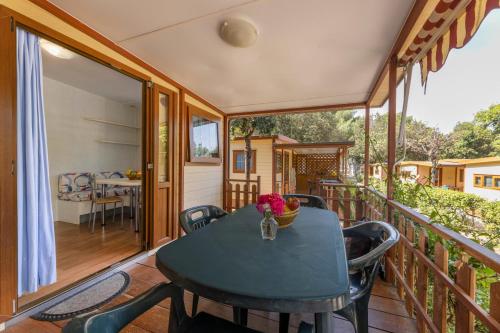 a room with a table and chairs on a balcony at Camping Village Le Calanchiole in Capoliveri