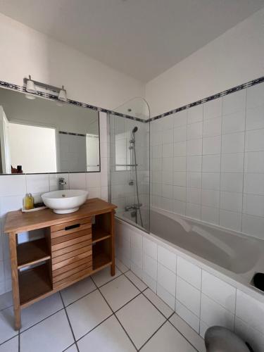 une salle de bain avec un lavabo, une baignoire et un miroir dans l'établissement 18 Rue Général Périer, à Nîmes