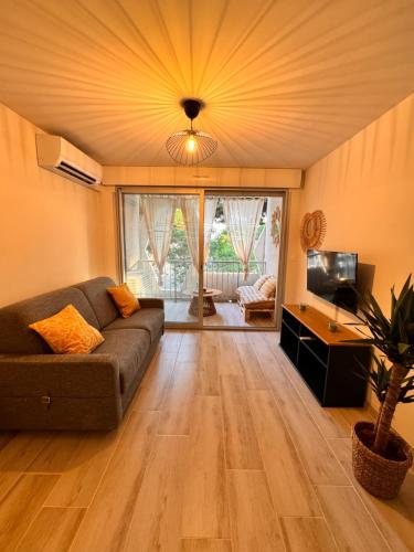 un salon avec un canapé et une télévision dans l'établissement Les Appartements De Lina -Studio Maya 5 - Self Check-In -, à La Grande Motte