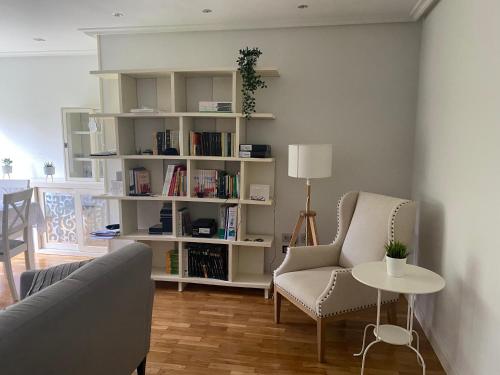 a living room with a couch and a book shelf at Apartamento residencial en Candás in Candás