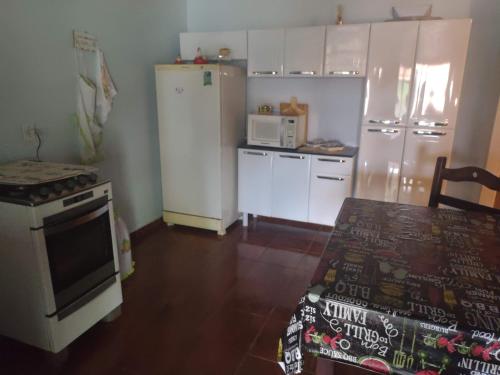 a kitchen with a refrigerator and a stove top oven at Casa com pisina infantil em Brotas in Brotas