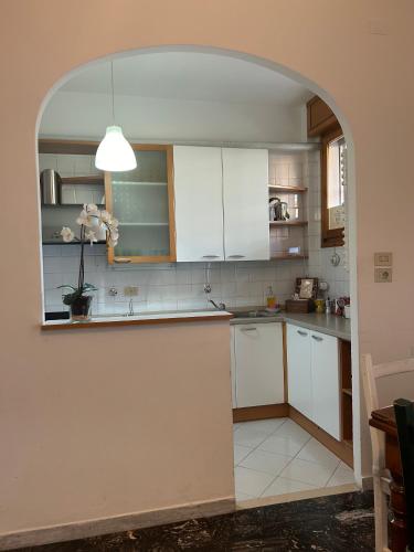 a kitchen with white cabinets and an archway at A CASA DI GIANCARLA in Bologna