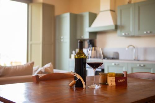 a bottle of wine and a glass on a table at Sangi Chianti Vacations in Poggibonsi