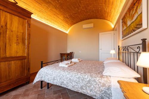 a bedroom with a bed and a wooden ceiling at Sangi Chianti Vacations in Poggibonsi
