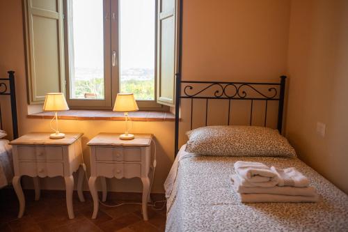 a bedroom with a bed and two night stands with lamps at Sangi Chianti Vacations in Poggibonsi