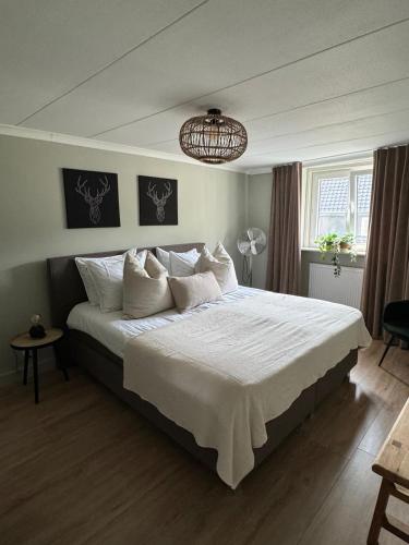 a bedroom with a large bed with white sheets and a chandelier at La Estancia Latinos in Valkenburg