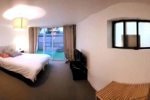 a hotel room with a bed and a window at Loft proche CDG 6 pers, Parc Expo avec parking in Villeparisis