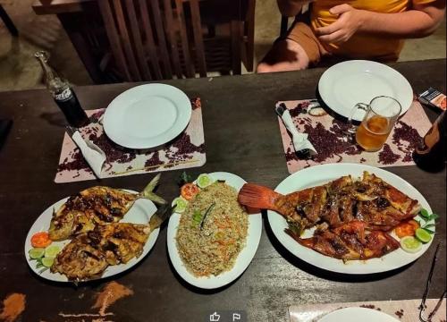 a table with plates of food and a spatula at Turtle Paradise in Tangalle