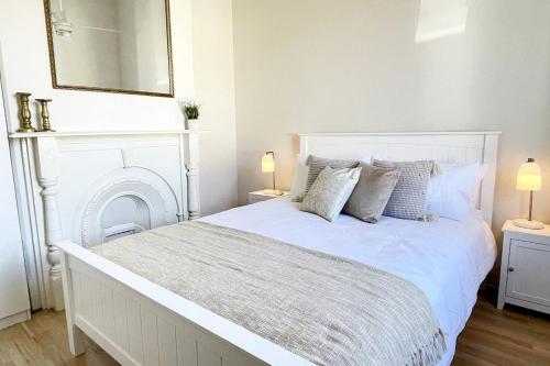 a white bedroom with a large white bed with pillows at Rosa's Place Close to South Beach in South Fremantle