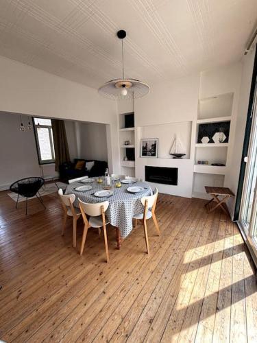 une table à manger et des chaises dans un salon dans l'établissement Ty Malo à deux pas de la plage, à Dunkerque