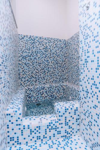 a blue tiled bathroom with a shower with blue tiles at Omare Apartments in Sant'Angelo D'Ischia