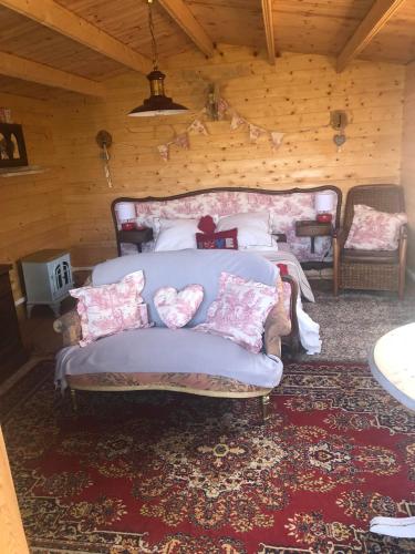 - une chambre avec un lit et un canapé avec des oreillers dans l'établissement The Love Shack, à Commana