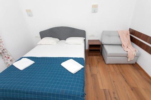 a small bedroom with a bed and a chair at Casa Ormenisan in Baile Felix