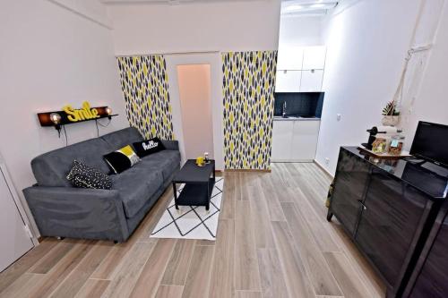 un salon avec un canapé et une cuisine dans l'établissement Cosy studio LEMONADE in Bastille, à Paris