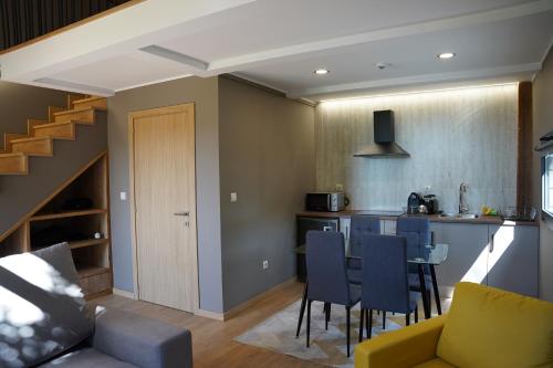 a kitchen and living room with a table and chairs at Quinta das Vianas - Casas do Picadeiro in Monção