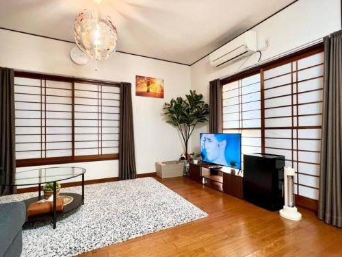a living room with a couch and a tv at FUKU House in Tokyo