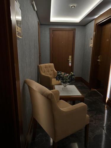a waiting room with two chairs and a table and flowers at Grand Star Hotel Premium in Istanbul