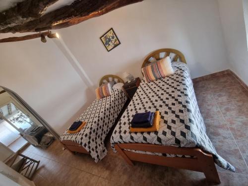 two beds sitting in a room with at Casa Arriba Village House in Zarra in Zarra