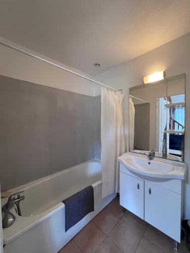 une salle de bain avec un lavabo, une baignoire et un miroir dans l'établissement La villa De Lina 416 -Self Check In, à Gallargues-le-Montueux