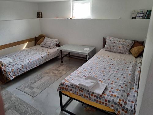 a bedroom with two beds and a table in it at Apartmani Drndić Sjenica in Sjenica