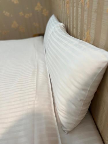 a close up of a white bed with a pillow at 微楓民宿 可加購晚餐酸白菜火鍋 in Renai