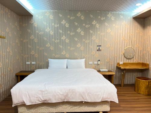 a bedroom with a large white bed in it at 微楓民宿 可加購晚餐酸白菜火鍋 in Renai