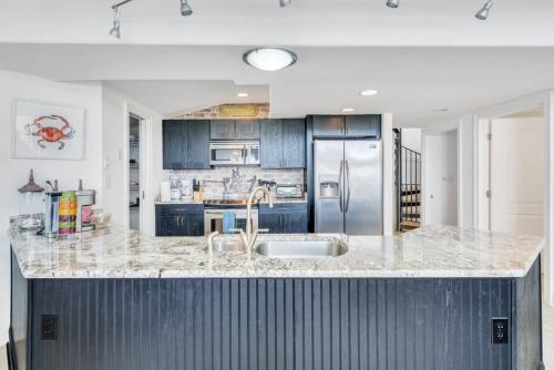 a kitchen with a sink and a refrigerator at Lakefront 3BR w Balconies Near French Qtr in New Orleans
