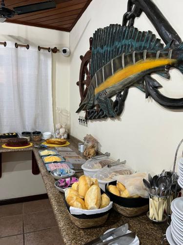 a buffet with bread and a fish on the wall at Pousada Sanhaço in Abraão