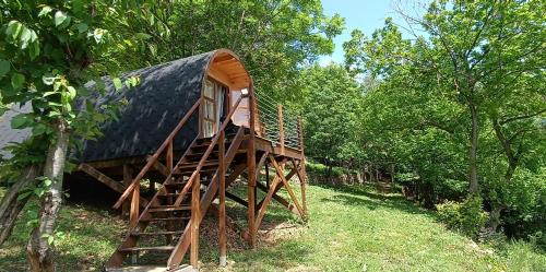 une maison avec un toit noir perchée dans les arbres dans l'établissement Le Temps Suspendu, à Saint-Pierreville