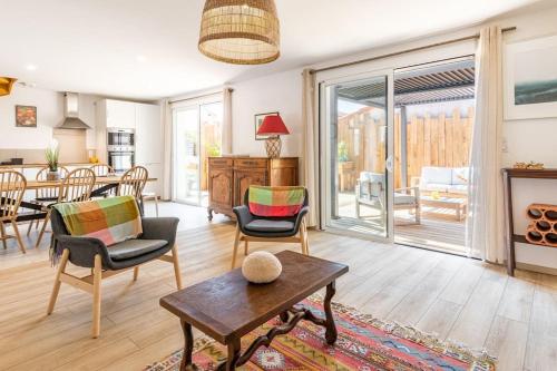 un salon avec une table et des chaises et une salle à manger dans l'établissement Appartement à 200 m de la plage, à Mimizan