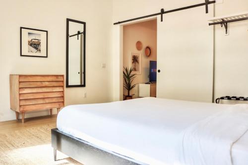 Un dormitorio con una cama blanca y una cómoda. en Executive Escape In Downtown San Diego, en San Diego