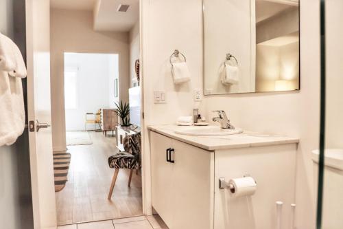 Un baño blanco con lavabo y espejo. en Executive Escape In Downtown San Diego, en San Diego