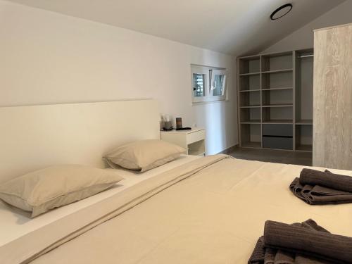 a white bedroom with a large bed with two pillows at Villa EnVi in Novalja