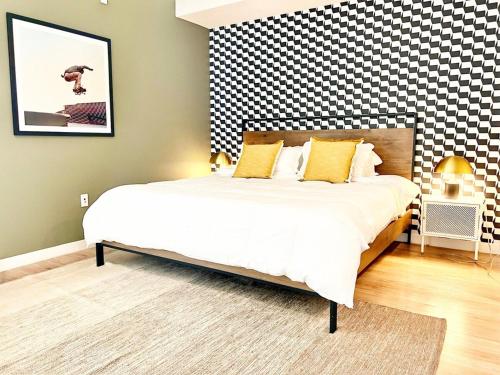 1 dormitorio con 1 cama grande y pared a cuadros en City View Apartment In Downtown!, en San Diego