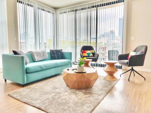 a living room with a blue couch and two chairs at 3 Bedroom Penthouse in Downtown! in San Diego