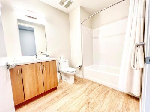Un baño con inodoro, lavabo y ducha. en Skyline Flat Facing Downtown San Diego, en San Diego