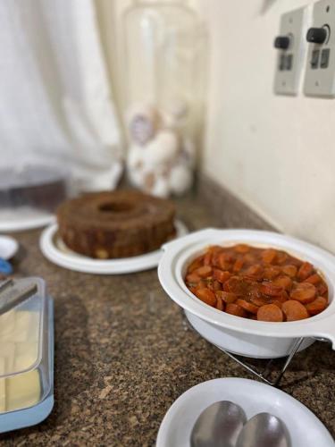 a counter top with a bowl of food and a cake at Pousada Sanhaço in Abraão