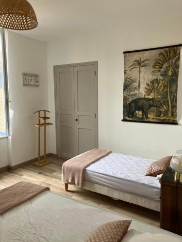 une chambre avec un lit et un tableau au mur dans l'établissement Maison Corbieres, à Peyriac-de-Mer